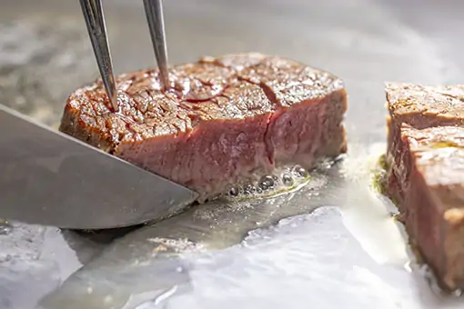 Juicy steak being grilled with smoke for gourmet meal