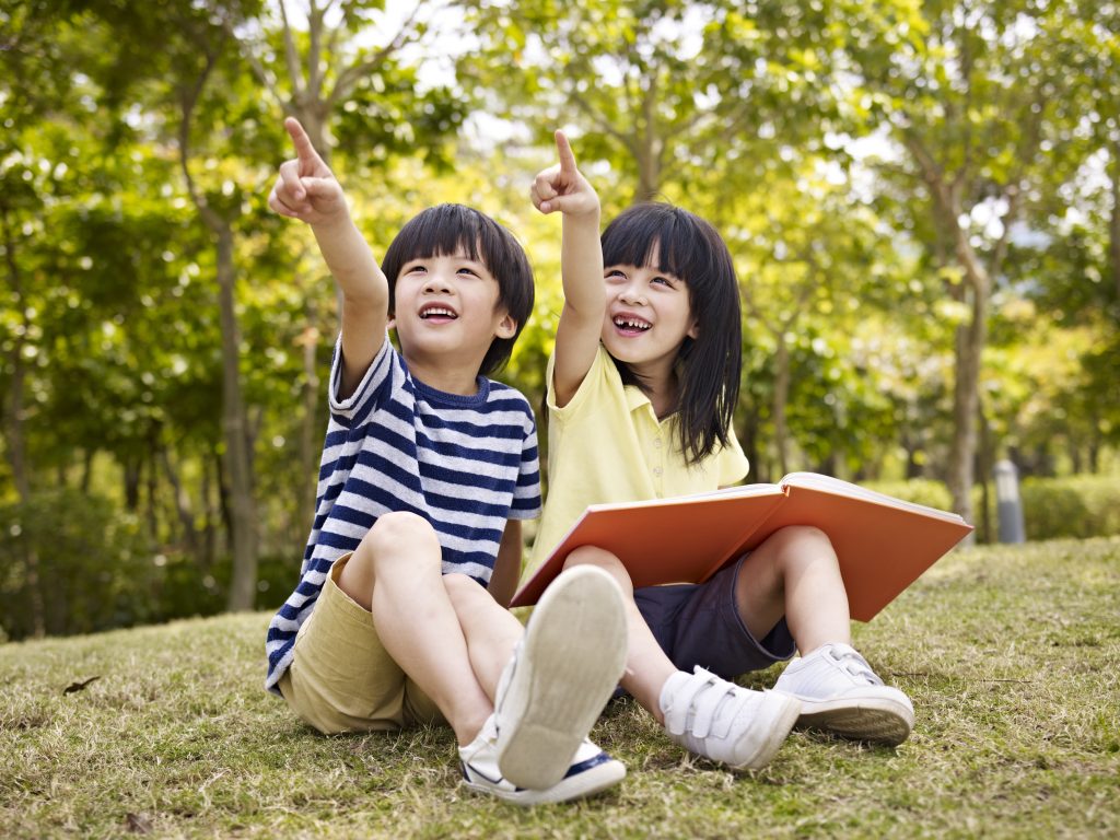 Little,Asian,Boy,And,Girl,With,Book,In,Hand,Sitting