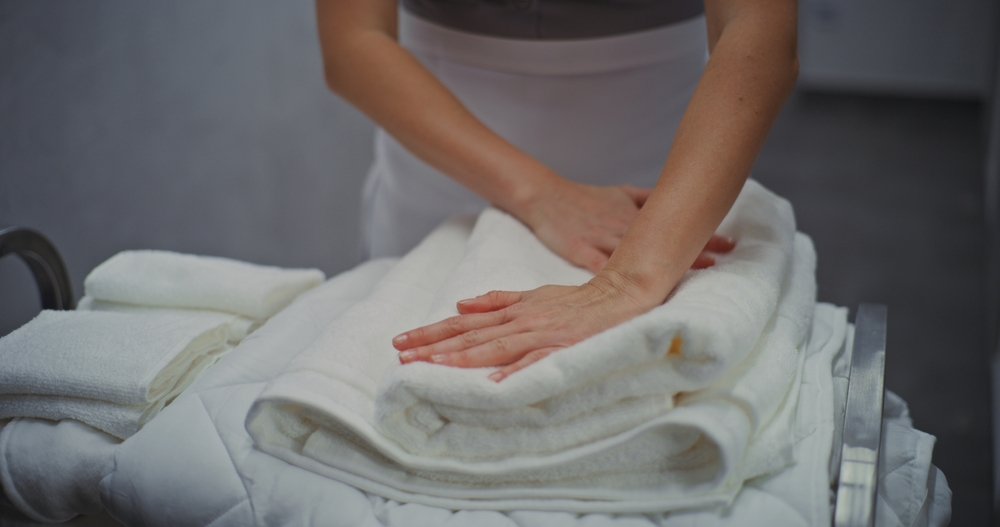 Close,Up,Of,Maid,In,Uniform,Attentively,Sorting,And,Folding